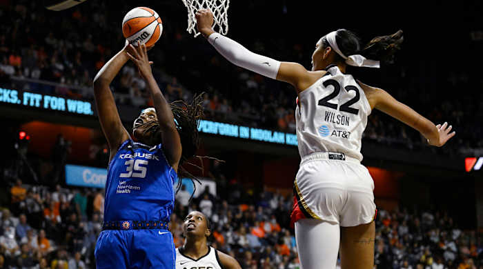 Sun's Jonquel Jones shoots as Las Vegas Aces' A'ja Wilson defends.